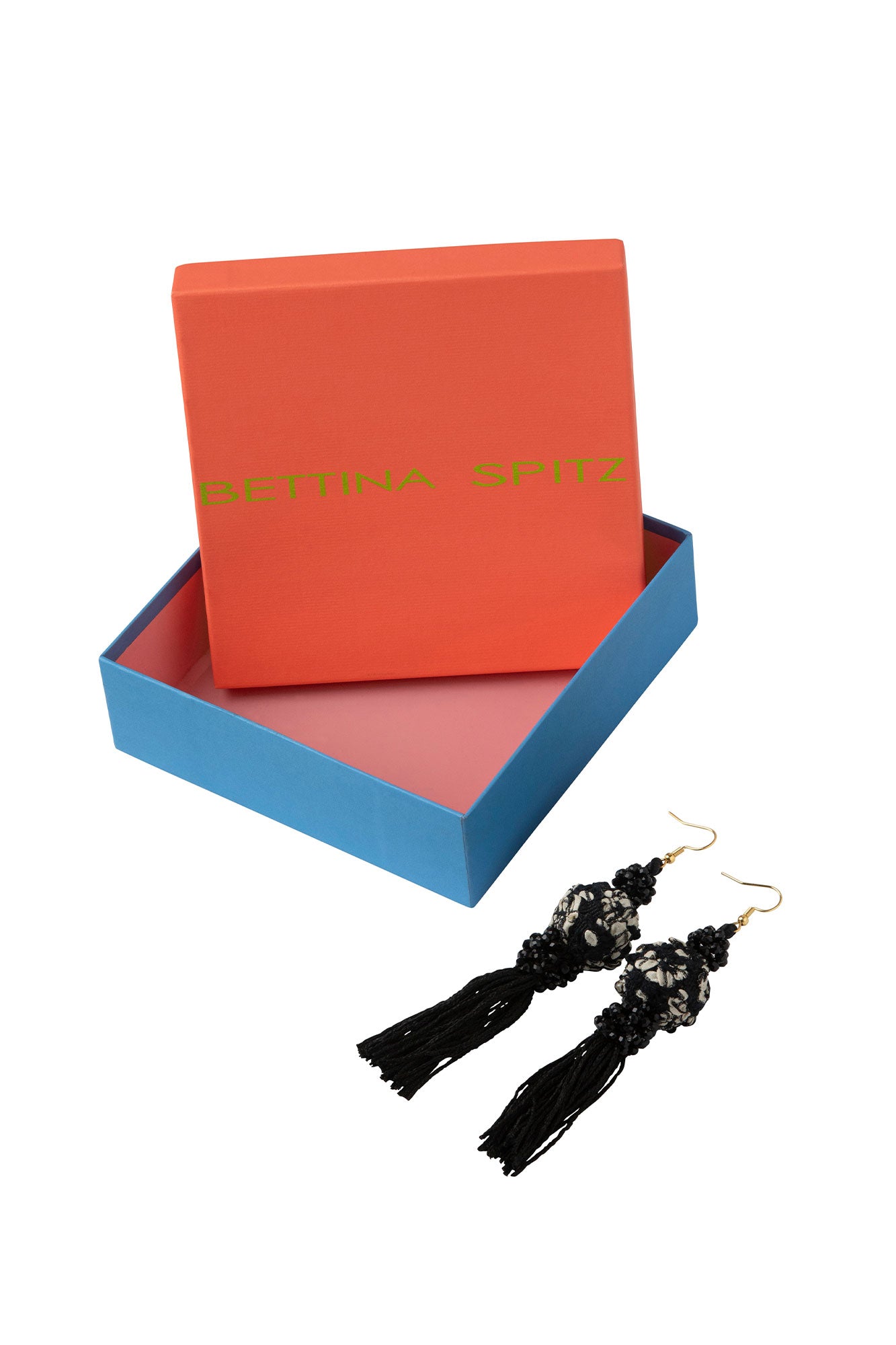Black tassel earrings with patterned spheres beside an orange and blue Bettina Spitz box