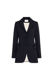 The Blazer Botón Rosa Navy Crepe Blazer — full front view showing wide notched lapel opening to ivory lining, three navy velvet rose-embossed buttons at center front, two hip flap pockets with velvet buttons, and fitted waist silhouette