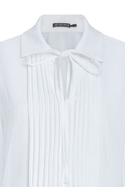 Close-up of ivory blouse showing front pintucks, pointed collar and narrow neck tie