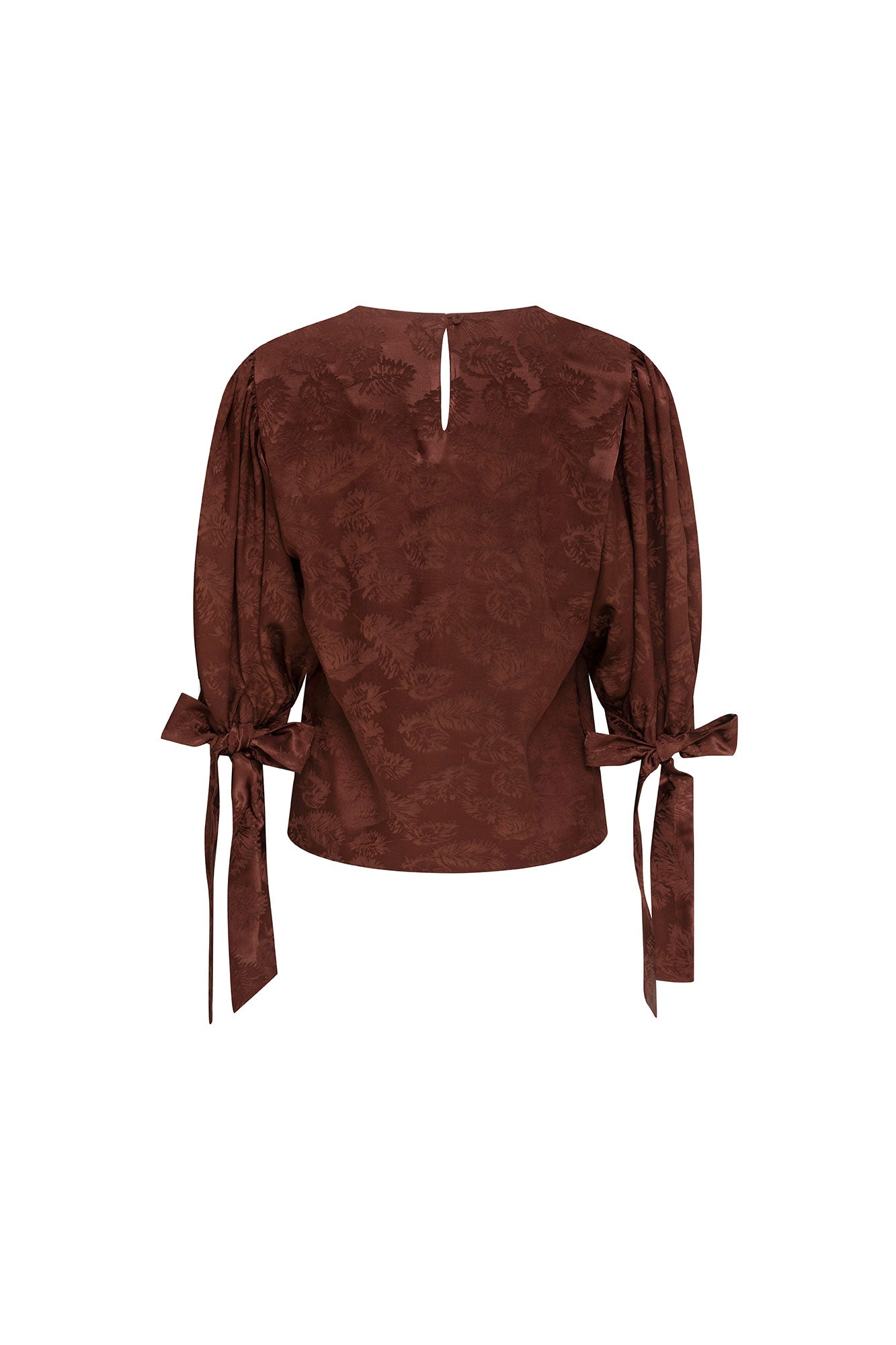 The Blusa Manga Puff Mono — full back view showing small keyhole opening at center back with single button closure, puff sleeve volume from shoulder, Bettina Spitz label at inner collar, and satin ribbon bow ties at both wrist cuffs