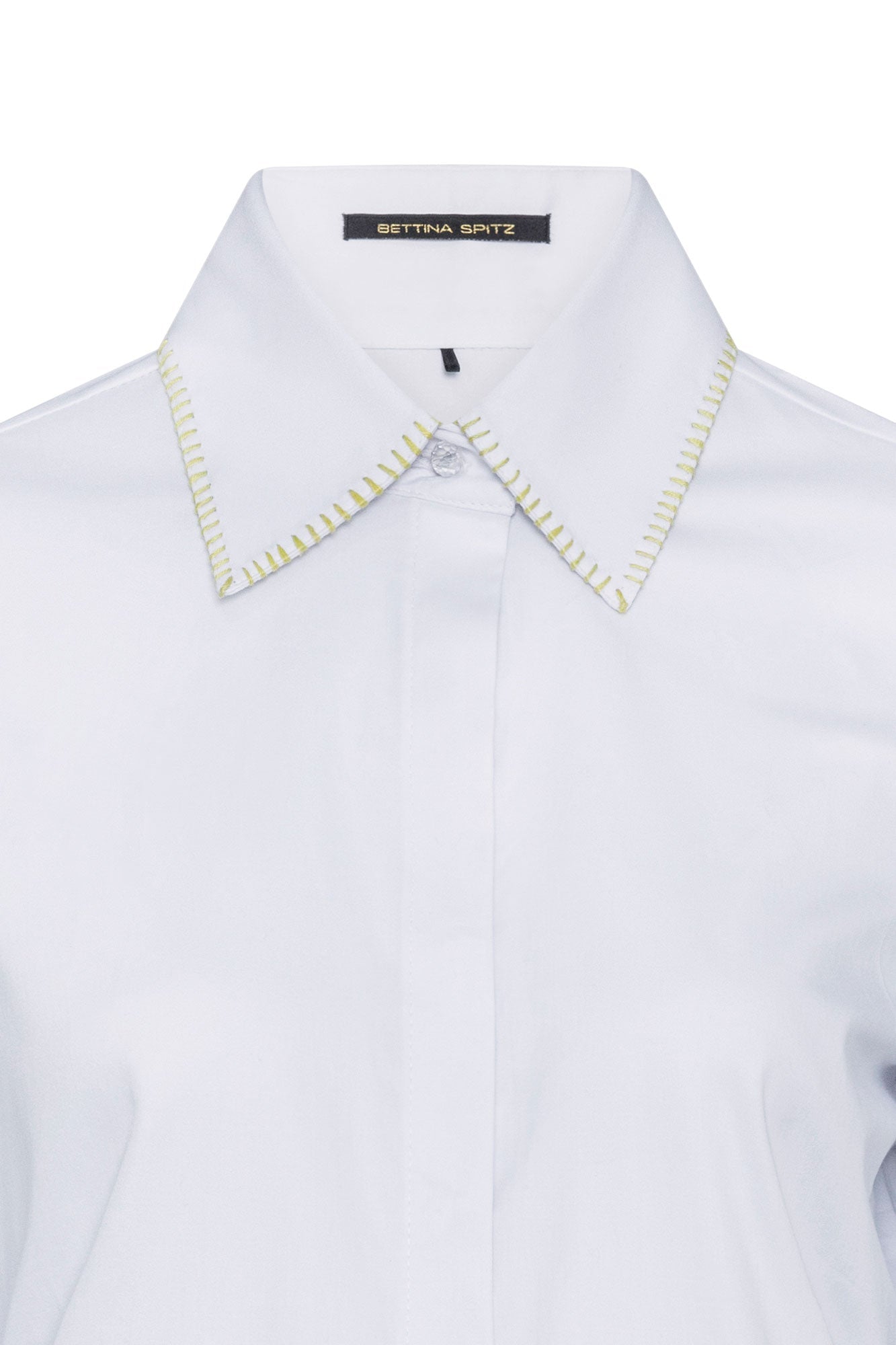 The Sol Nadadora White Shirt — close-up of yellow-green whipstitch collar detail and Bettina Spitz label