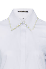 The Sol Nadadora White Shirt — close-up of yellow-green whipstitch collar detail and Bettina Spitz label