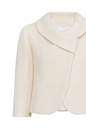 Close-up of ivory jacket showing asymmetric collar and curved overlapping front