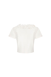 Crop Manguita CR Flor Ivory — full back view showing fitted ivory cropped short-sleeve top with plain ivory stretch fabric body and hand-applied 3D flower collar visible at neckline edge across shoulders