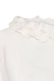 Crop Manguita CR Flor Ivory — close-up of 3D fabric flower collar showing individually constructed multi-petal ivory blooms in varying sizes, layered and shaped by hand, sitting voluminously on top of the ivory stretch fabric neckline