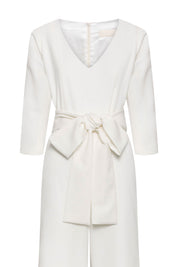 The Enterizo V Ivory Wide-Leg Jumpsuit — close-up of self-fabric tie belt bow and V-neckline button detail