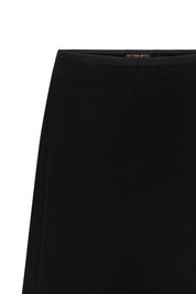 Close-up of black skirt showing narrow ribbon waistband and plain fabric