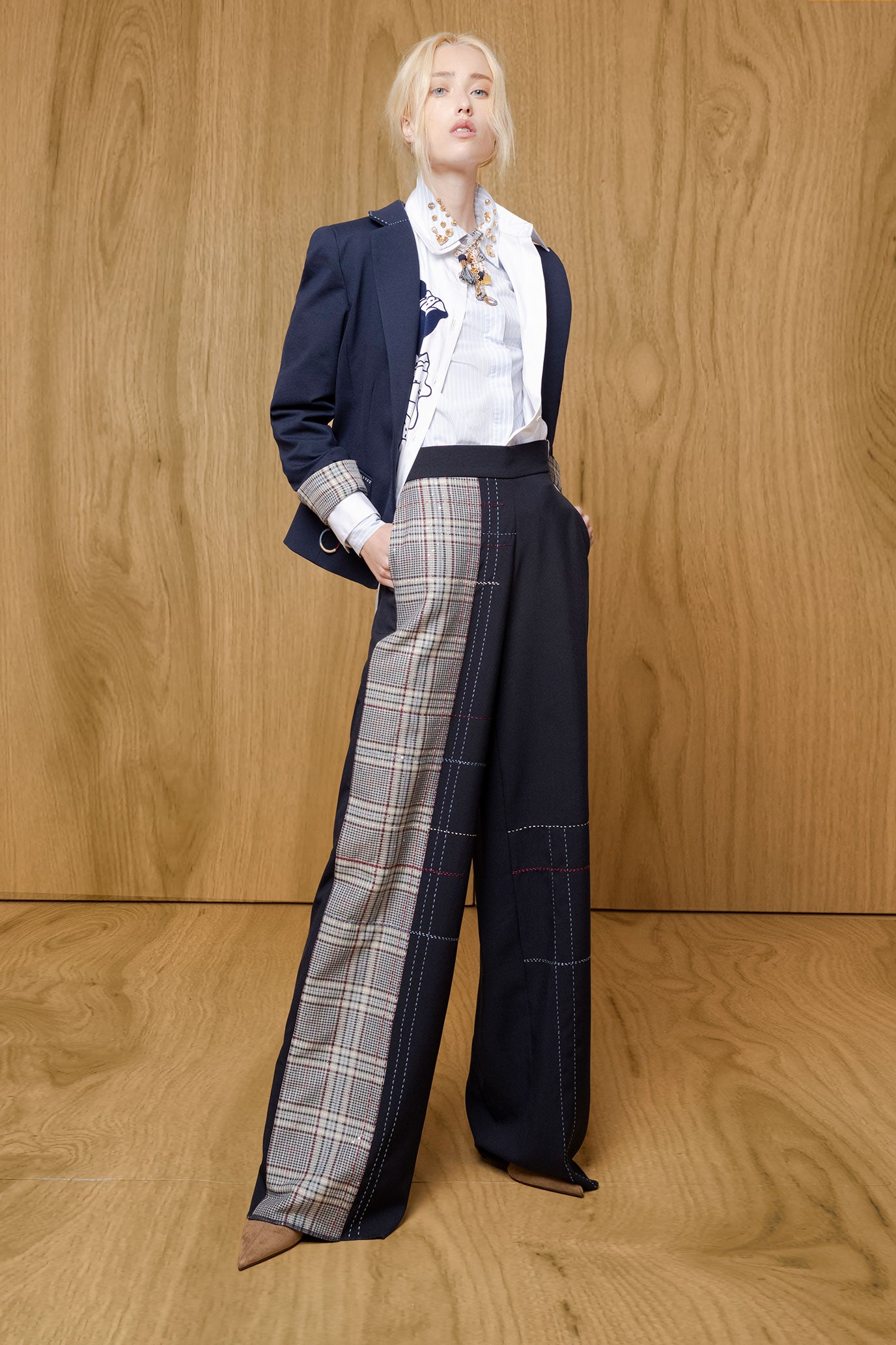Model wearing Bettina Spitz navy wide-leg Milo trousers with a check panel, white shirt and navy blazer