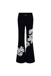 The Jean Campana Flor Hilo Navy — full front view showing high-rise dark navy stretch denim flare jeans with single gold button at waistband, contrast topstitching, and large-scale white botanical iris and peony embroidery across right thigh panel and left flare