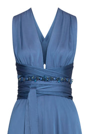 Close-up of blue maxi dress showing gathered neckline, crossed waist ties and blue beaded embellishment