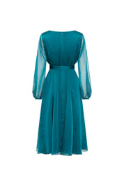 Back view of green midi dress showing sheer long sleeves, defined waist and softly flared skirt