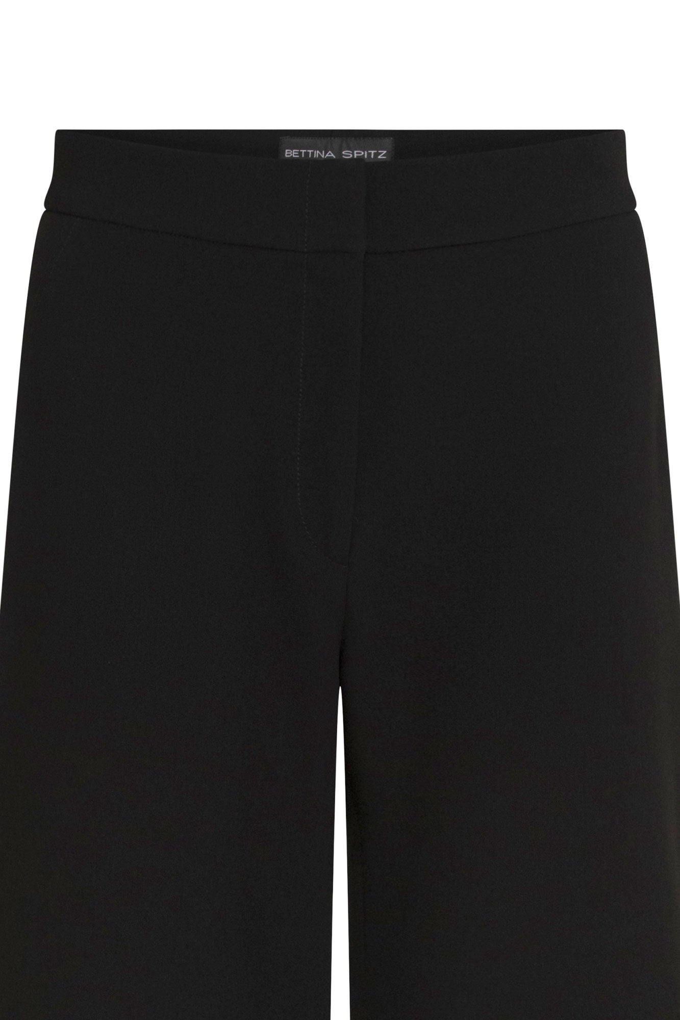 The Pantalón Gaby Campana Negro — close-up of clean wide waistband showing Bettina Spitz label at center back interior and smooth structured black fabric with no hardware or pocket detail