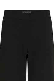 The Pantalón Gaby Campana Negro — close-up of clean wide waistband showing Bettina Spitz label at center back interior and smooth structured black fabric with no hardware or pocket detail
