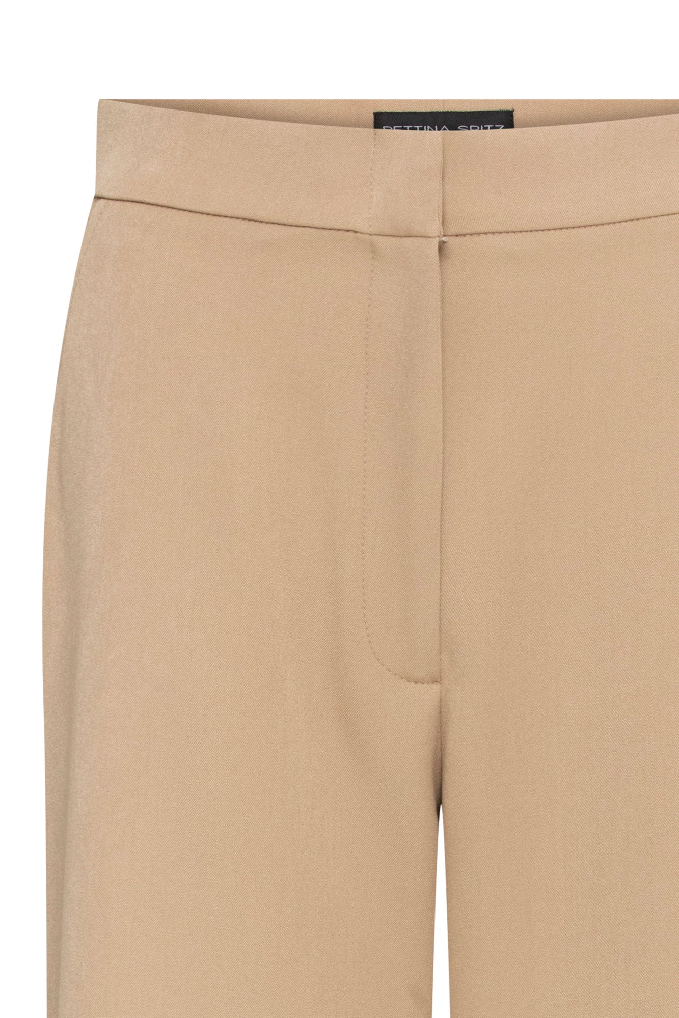 Pantalón Gaby Recto Arena — close-up of waistband and upper leg showing warm camel structured fabric, clean wide waistband with Bettina Spitz label at interior, concealed front placket, and discreet front slash pocket opening