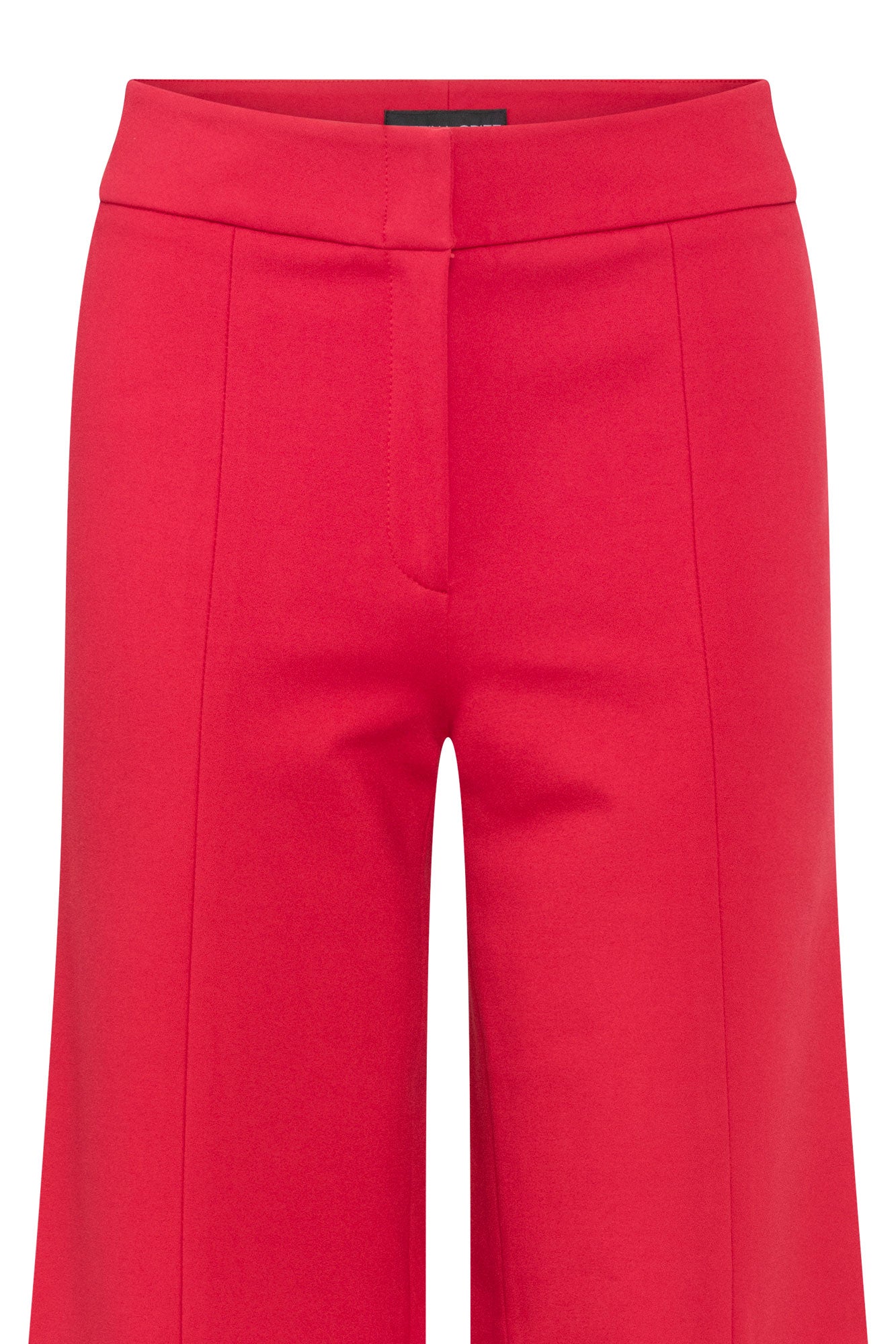 Close-up of red trousers showing waistband, concealed front fastening and vertical front seams