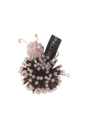 Close-up of Bettina Spitz Catarina brooch with dark brown strips, pale pink beads and gold-toned wire legs and antennae