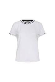 The T-Shirt Vivo Pespunte Flores Blanco — full front view showing fitted white cotton t-shirt with flat black neckline trim band and single row of small embroidered white daisy flowers, narrow black sleeve hem trim with dotted topstitch and three daisy flowers at outer cuff edge