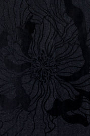 The Flor Black Ribbed Midi Dress — detail of velvet-like raised petal embroidery, black on black