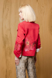 Back model view of red Cayena jacket showing large floral motifs across the lower back and sleeves